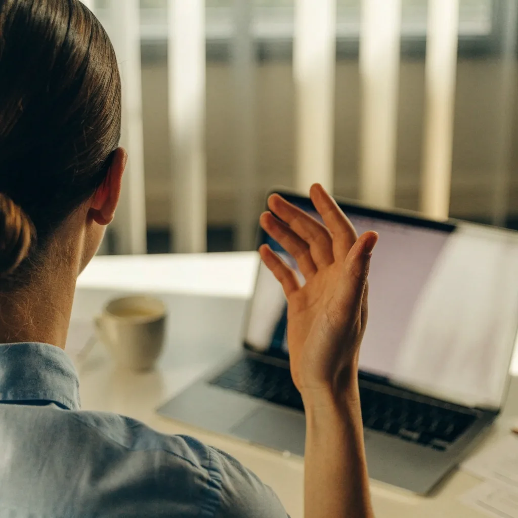 Two people on a first consultation call in a bright office, seen from behind the desk